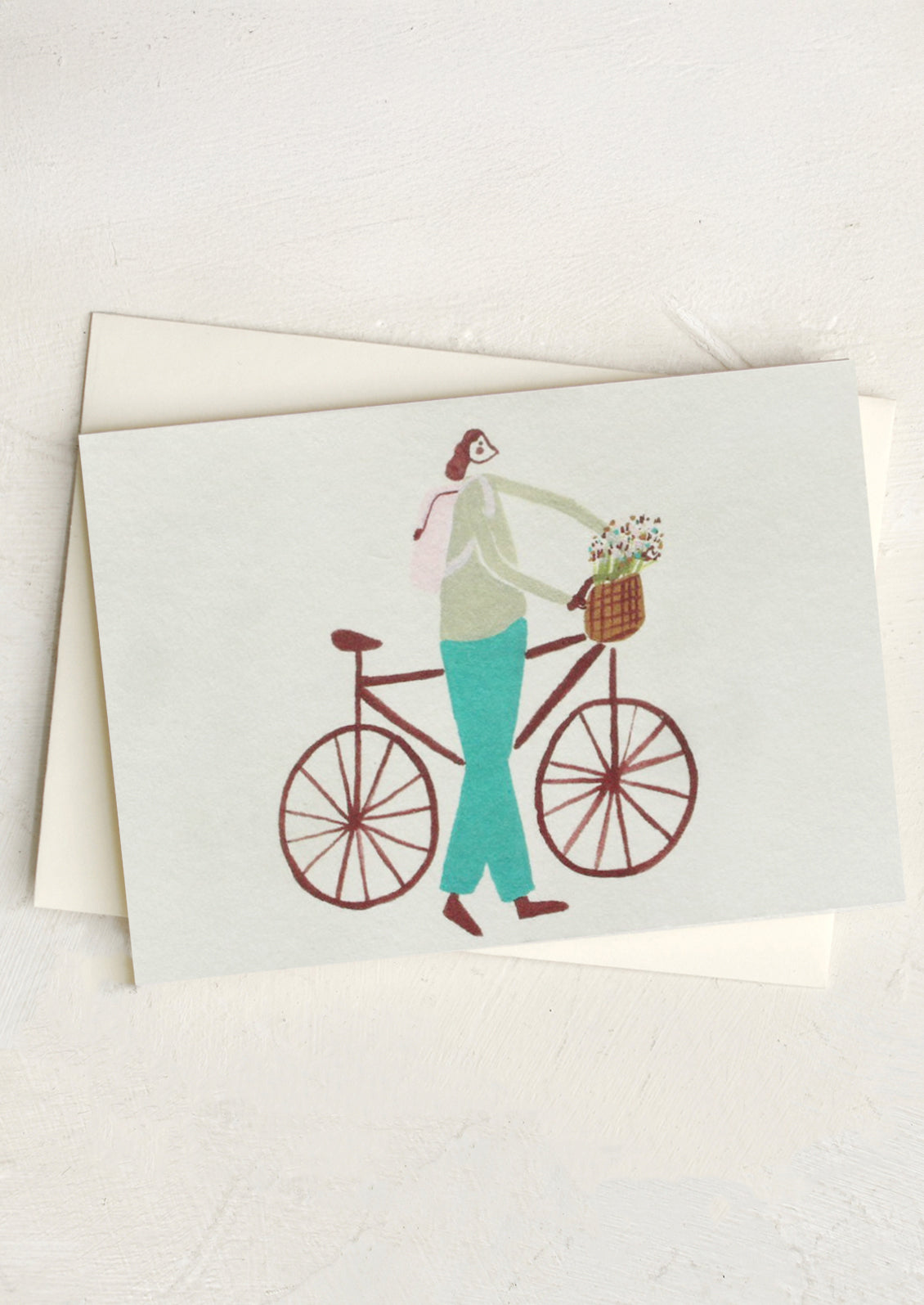 Card with illustration of a person on a bicycle carrying flowers, on a white background.