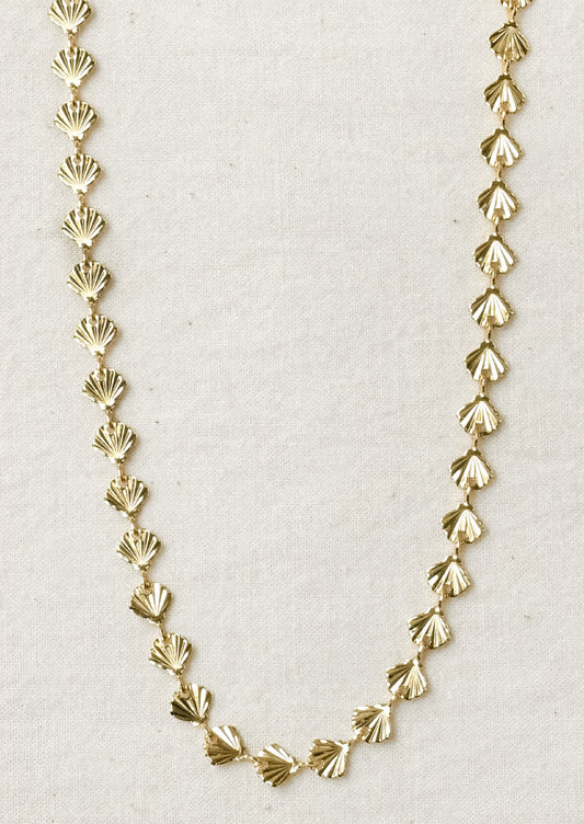 A gold necklace composed of tiny gold seashells.