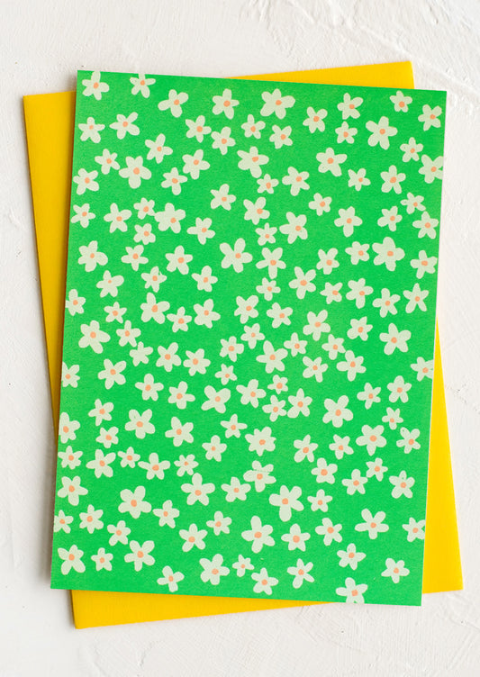 A neon green card with allover white flower print.