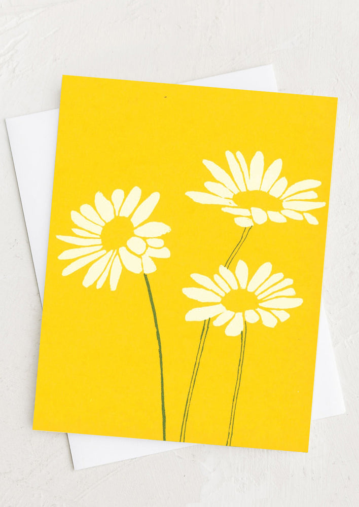 A yellow greeting card with silk screened daisy design.