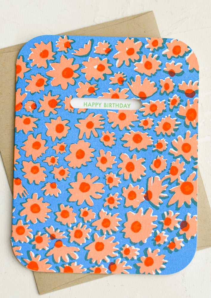 A blue and peach daisy print card with window revealing "Happy Birthday" text.