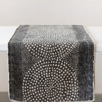 1: A charcoal table runner with cream medallion pattern.