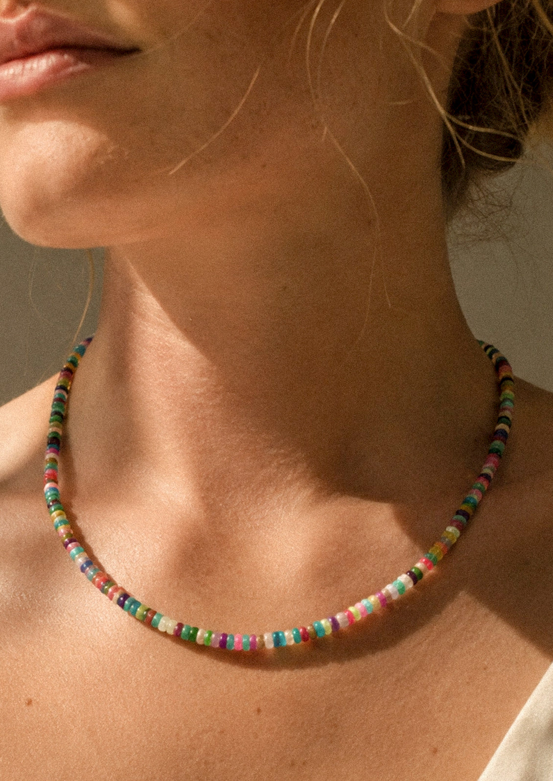 A woman wearing a colorful beaded necklace.