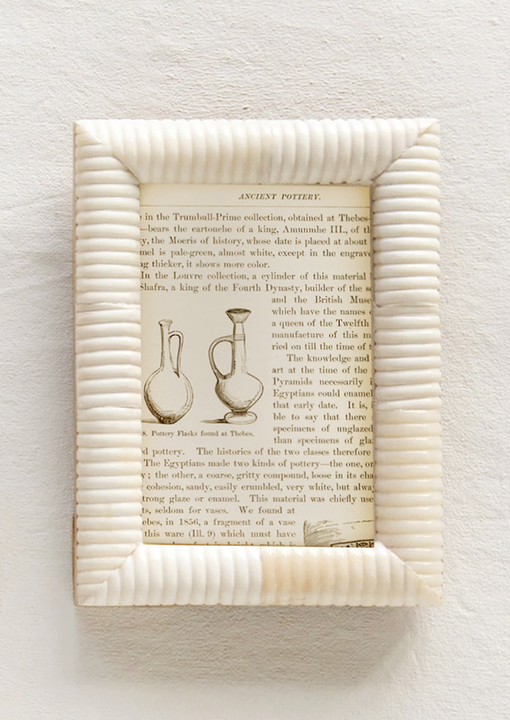 1: An ivory picture frame made of bone with puffy, ribbed border.