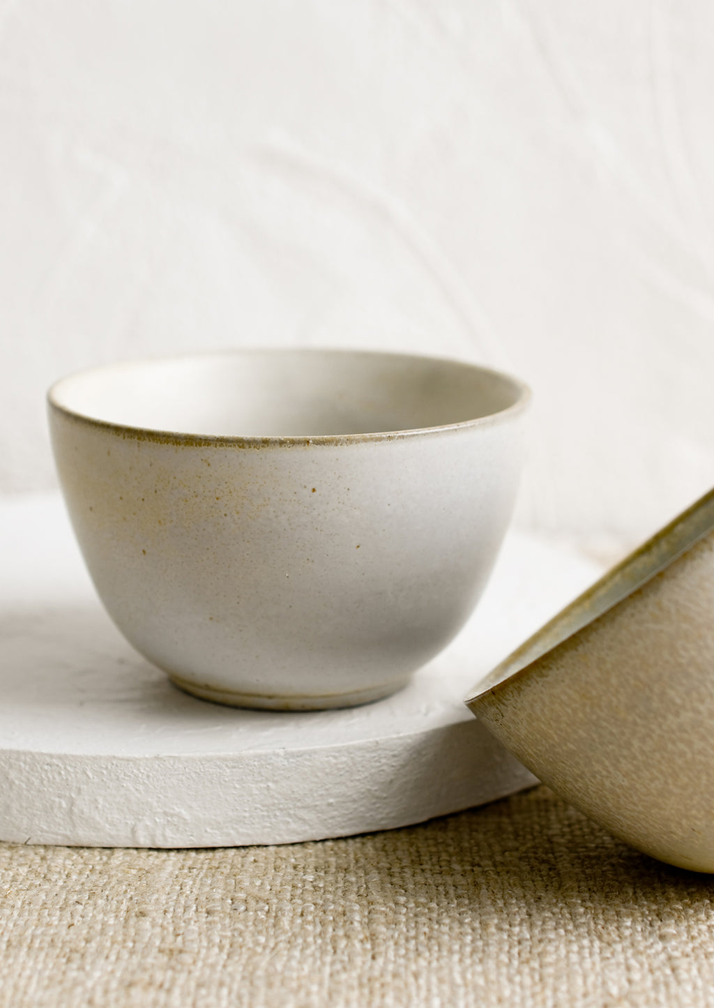 2: Two small ceramic bowls in natural speckle glazes.