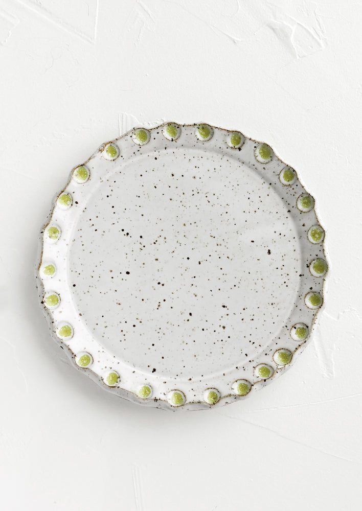 Glossy White Speckle / Apple Green: A round ceramic plate with green dot print detail.