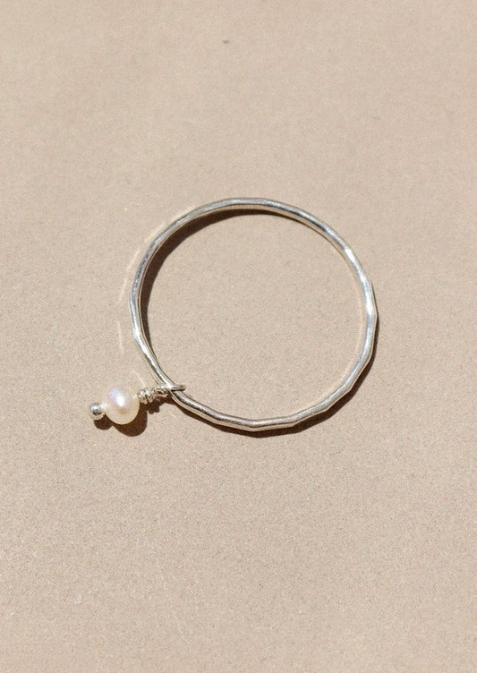 A sterling silver ring with dangling pearl bead.