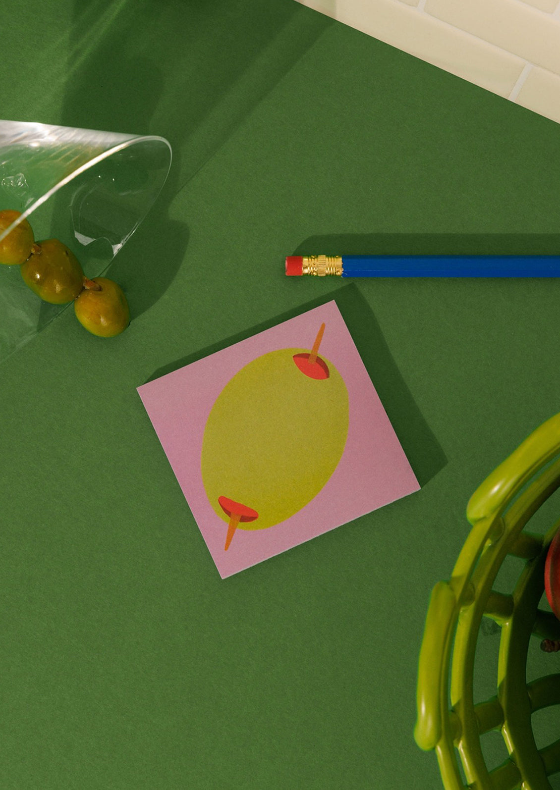 A stack of sticky notes with printed olive theme on pink background.