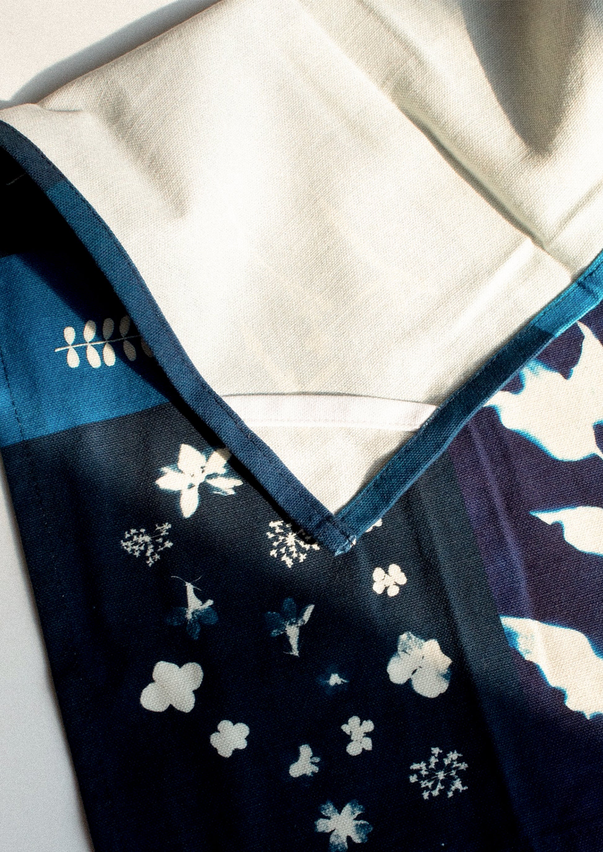 Navy blue fabric with white floral patterns on a white background