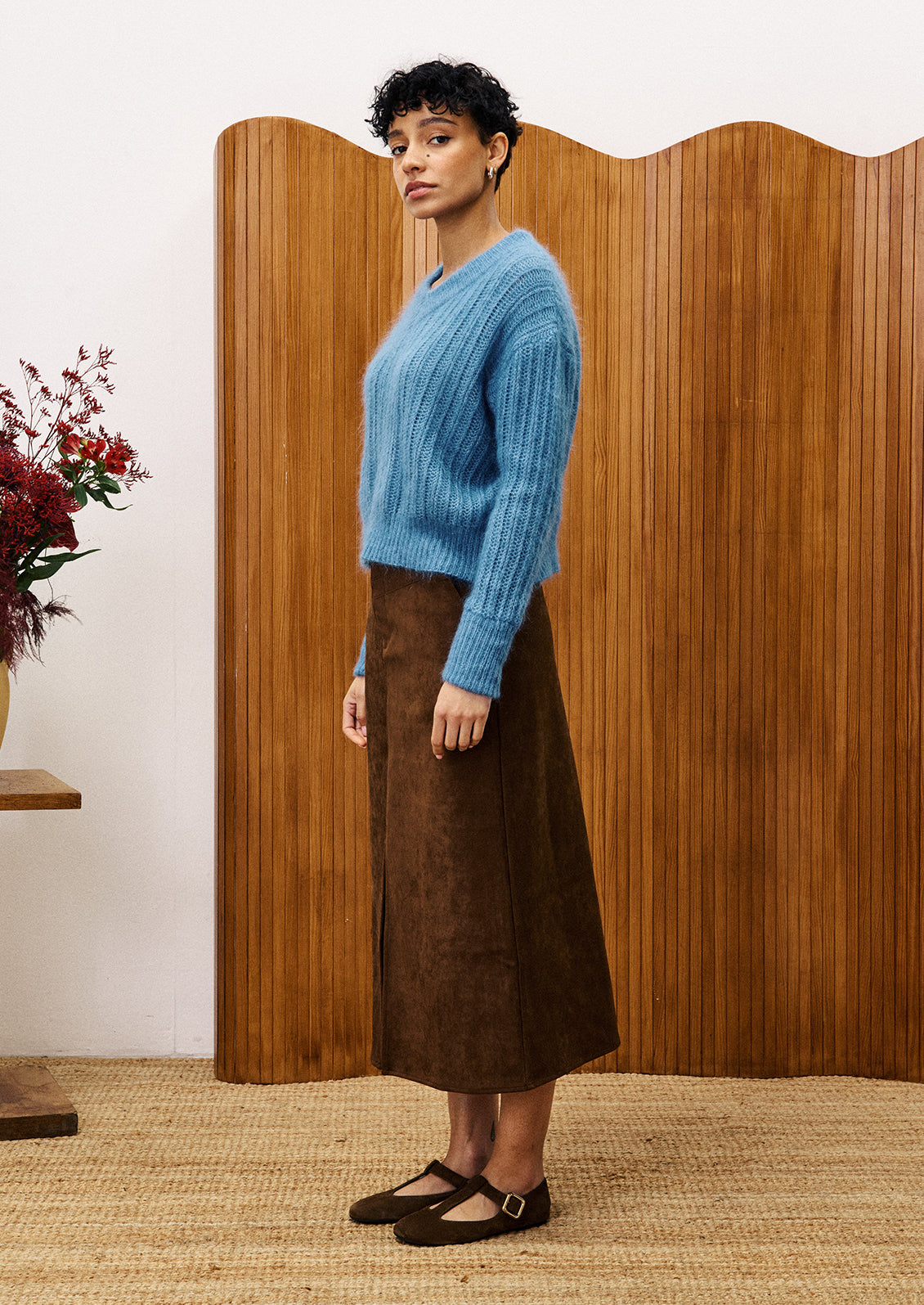 A woman wearing a dusty blue v-neck sweater.