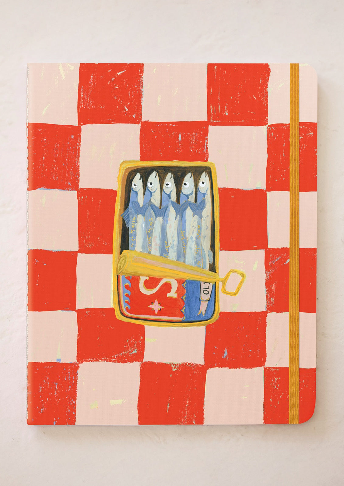 Notebook with a red and beige checkered pattern and a yellow band closure, featuring an illustration of sardines.