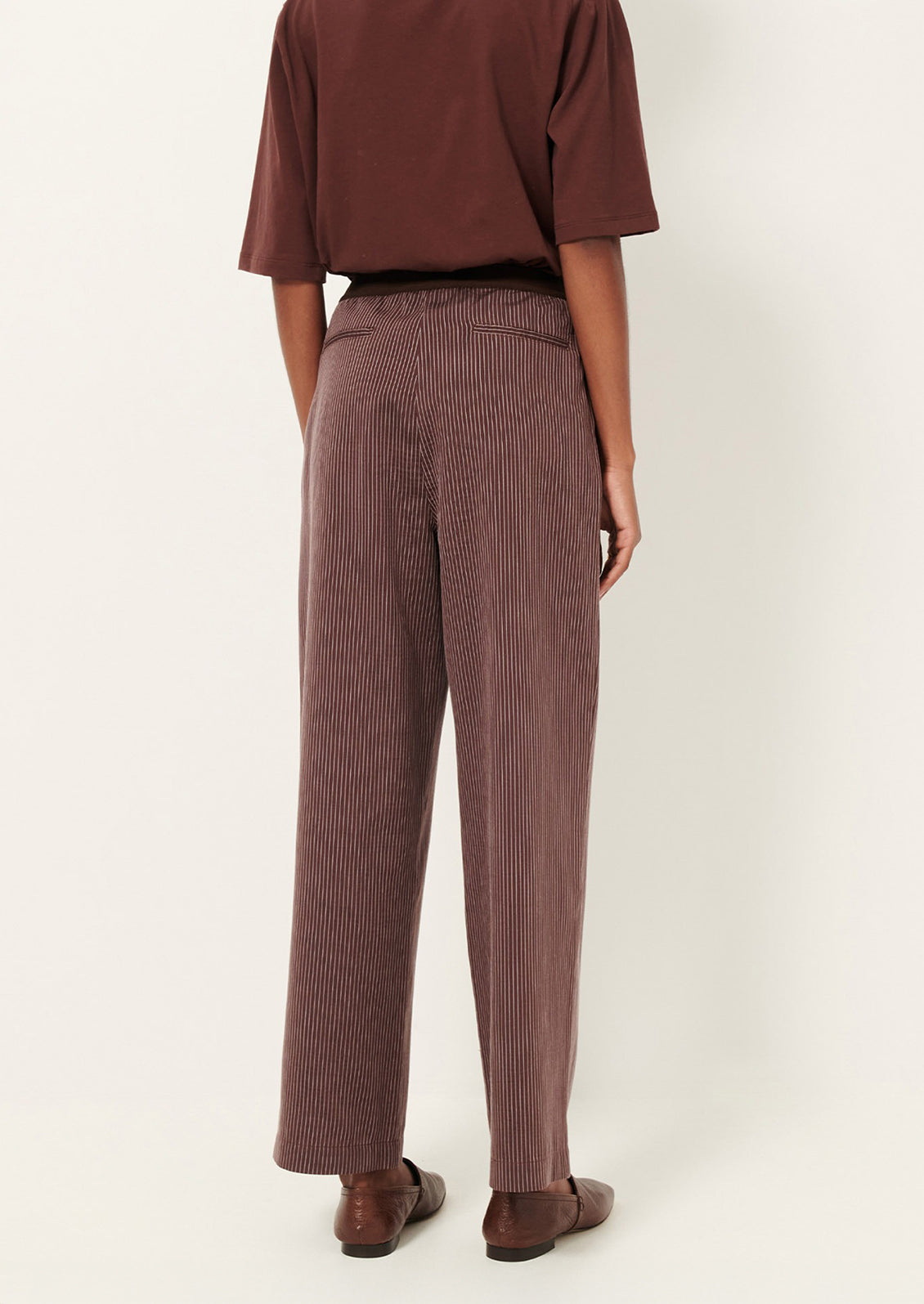 Brown pinstripe pants worn by a person.