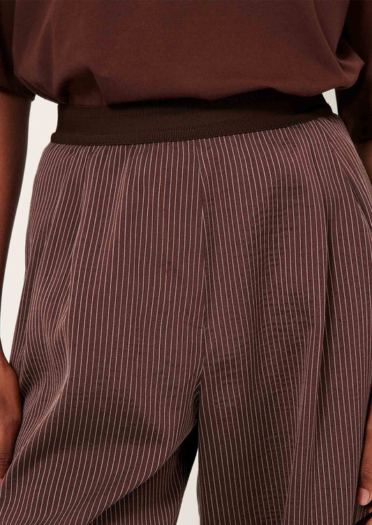 Brown pinstripe pants worn by a person.