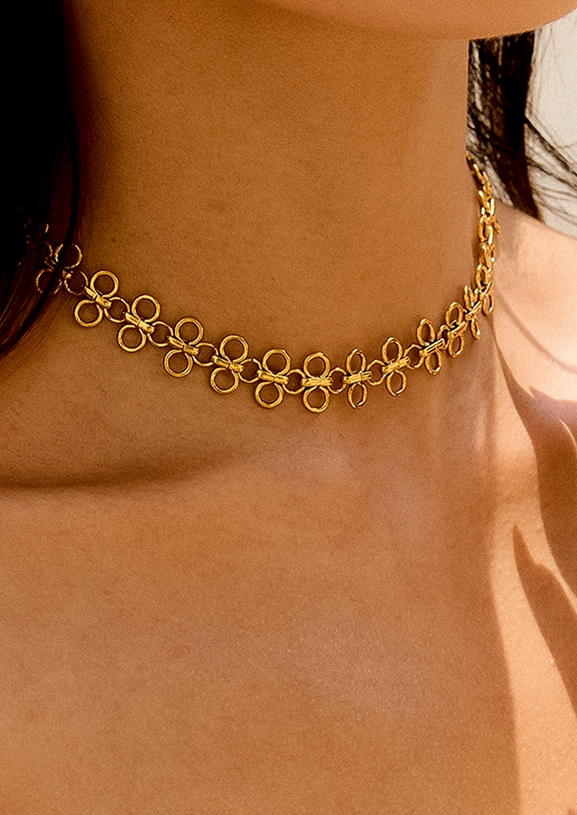 Gold chain necklace on a person's neck