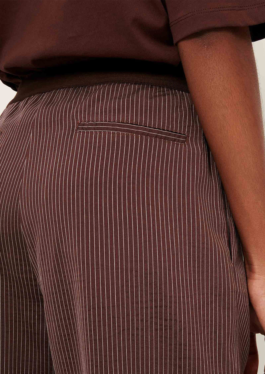 Brown pinstripe pants worn by a person.