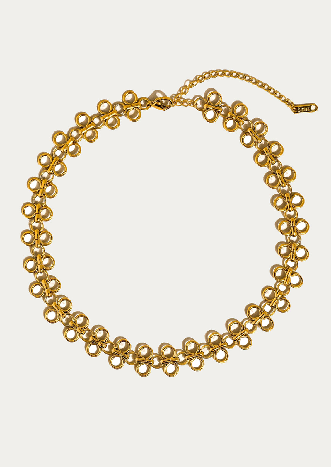 Gold chain necklace on a light gray background