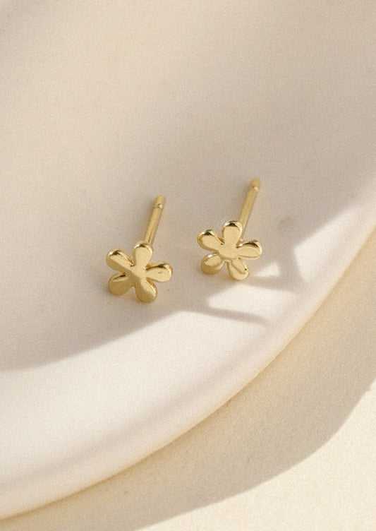 A pair of flower shaped stud earrings in gold.