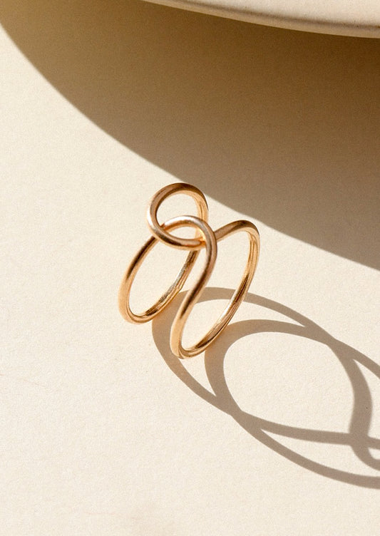 Gold ring with a minimalist design on a beige background