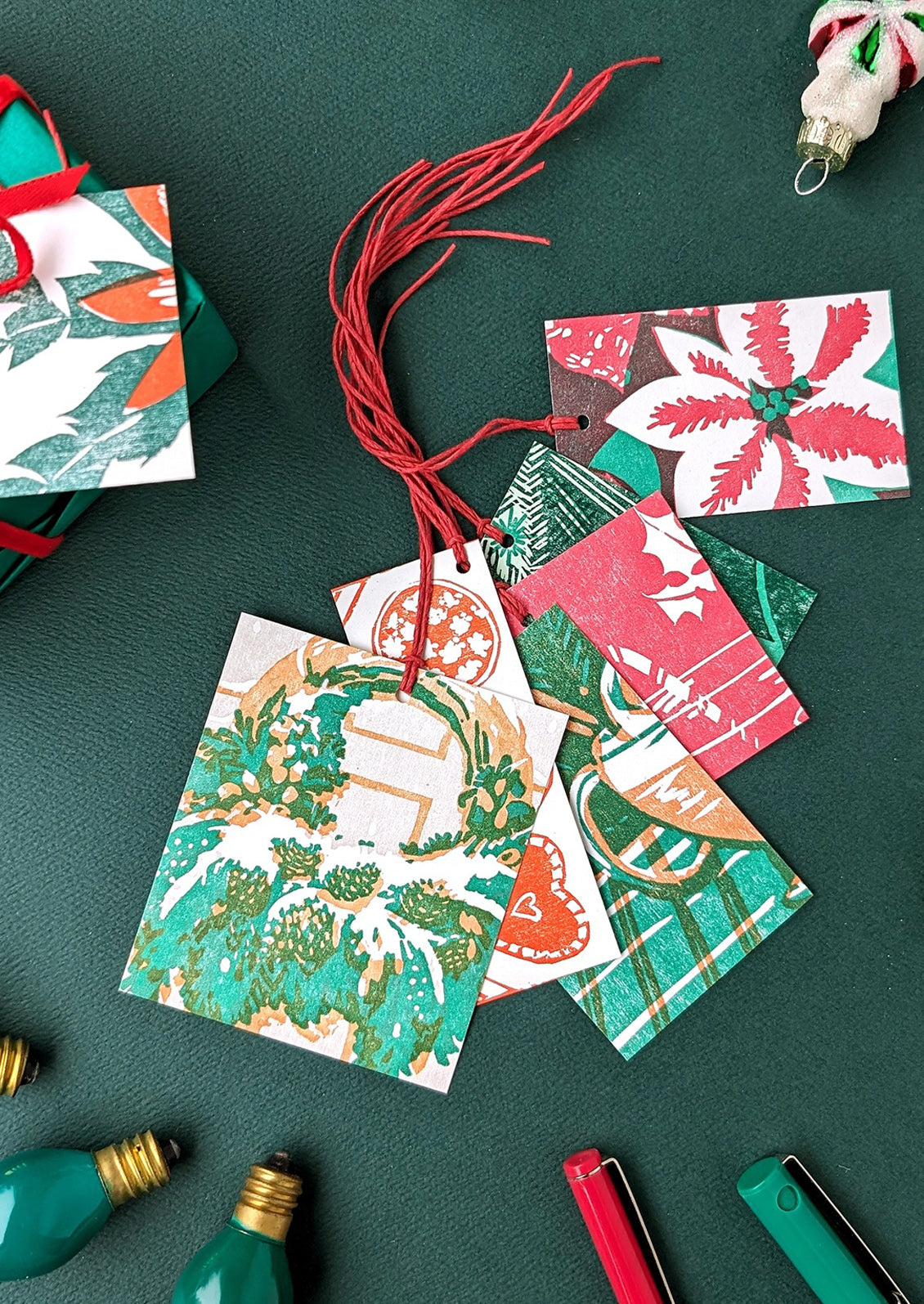Collection of Christmas-themed gift tags on a green surface with decorative elements.