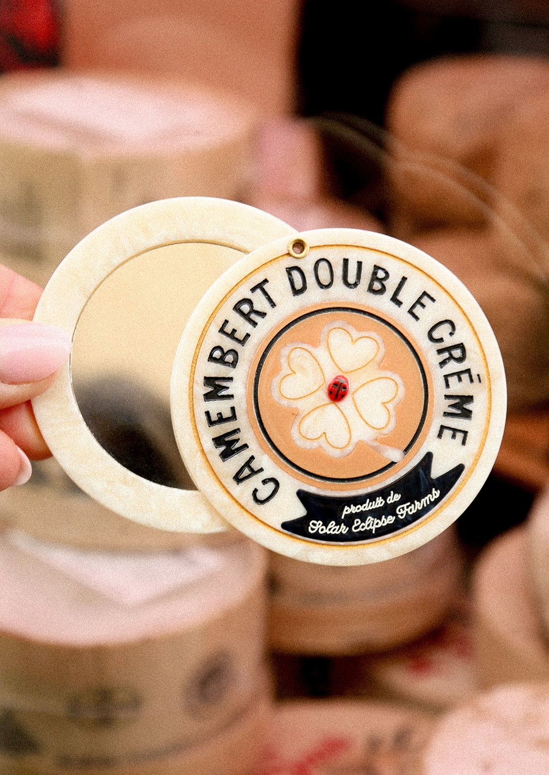 Cheese wheel shaped compact mirror.