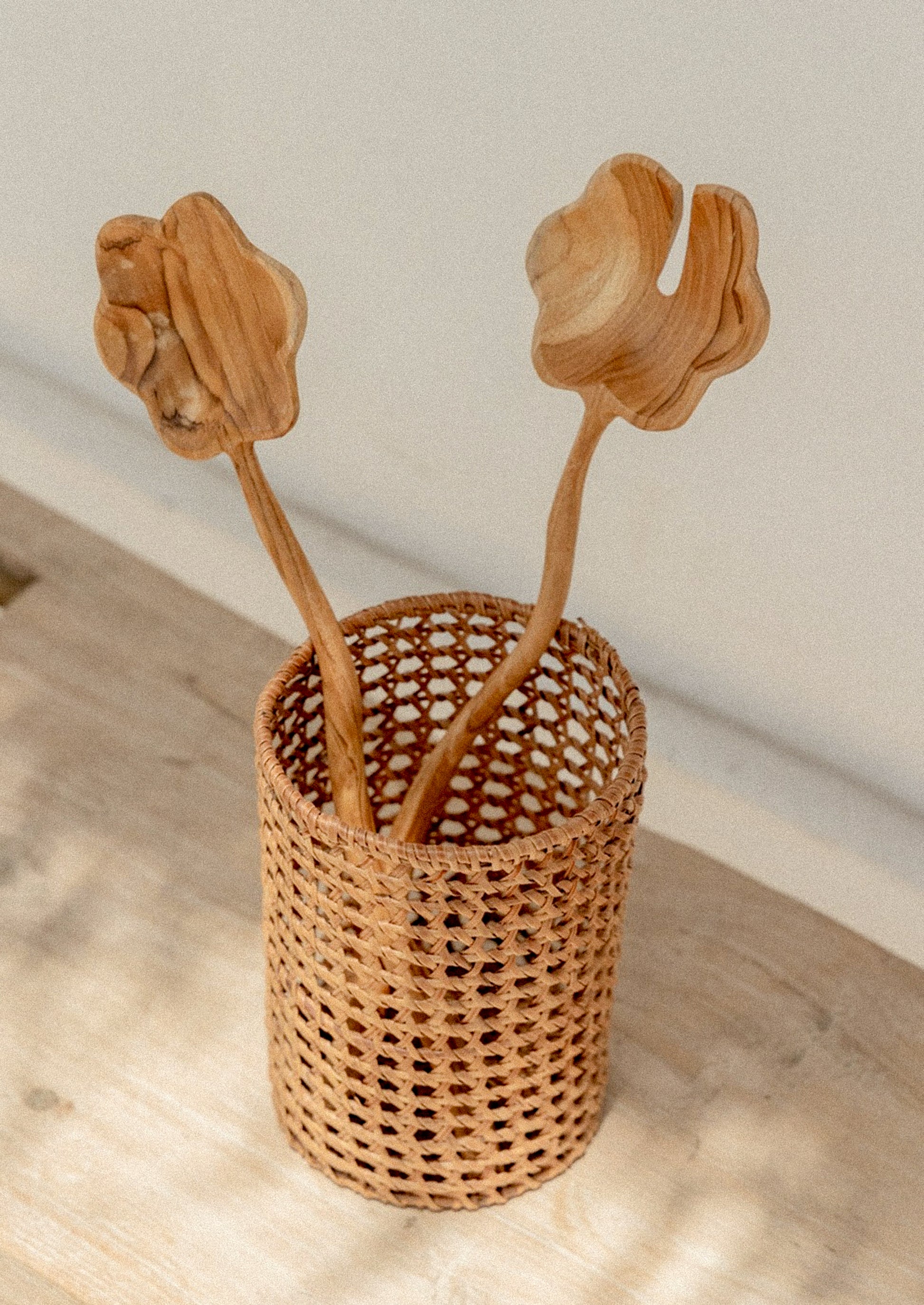 A pair of salad servers with flower shaped spoon and wavy handle.