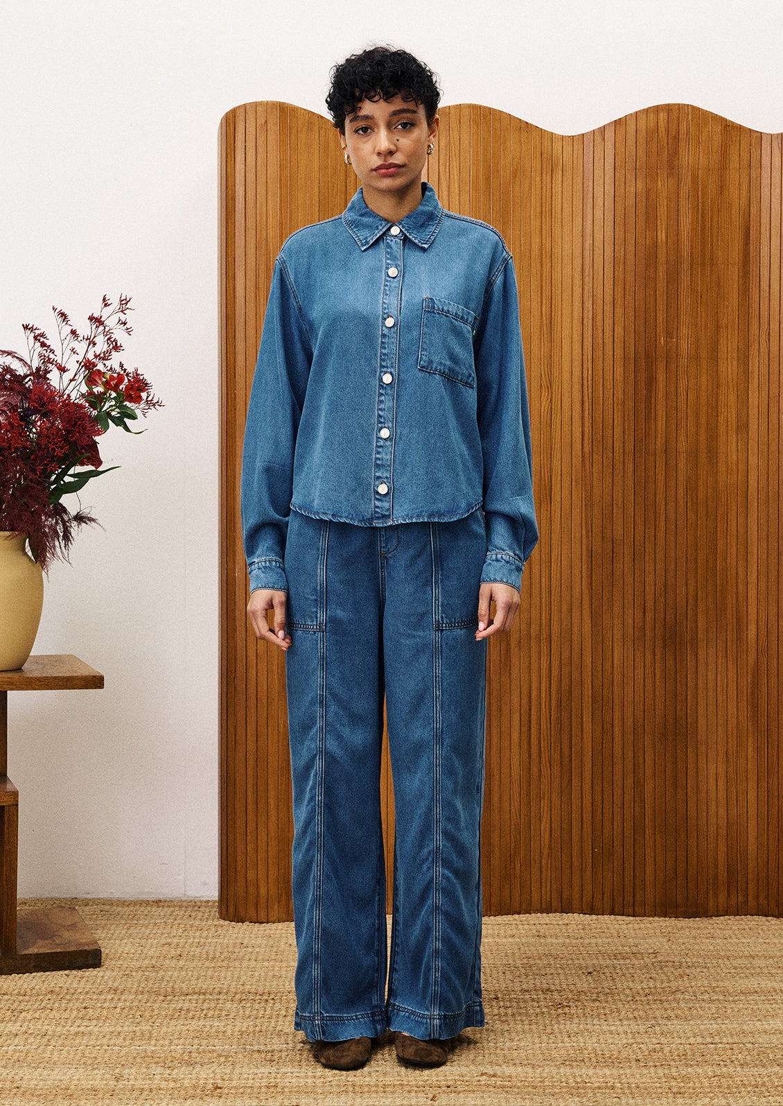 A pair of wide leg blue jeans with elasticized waistband.