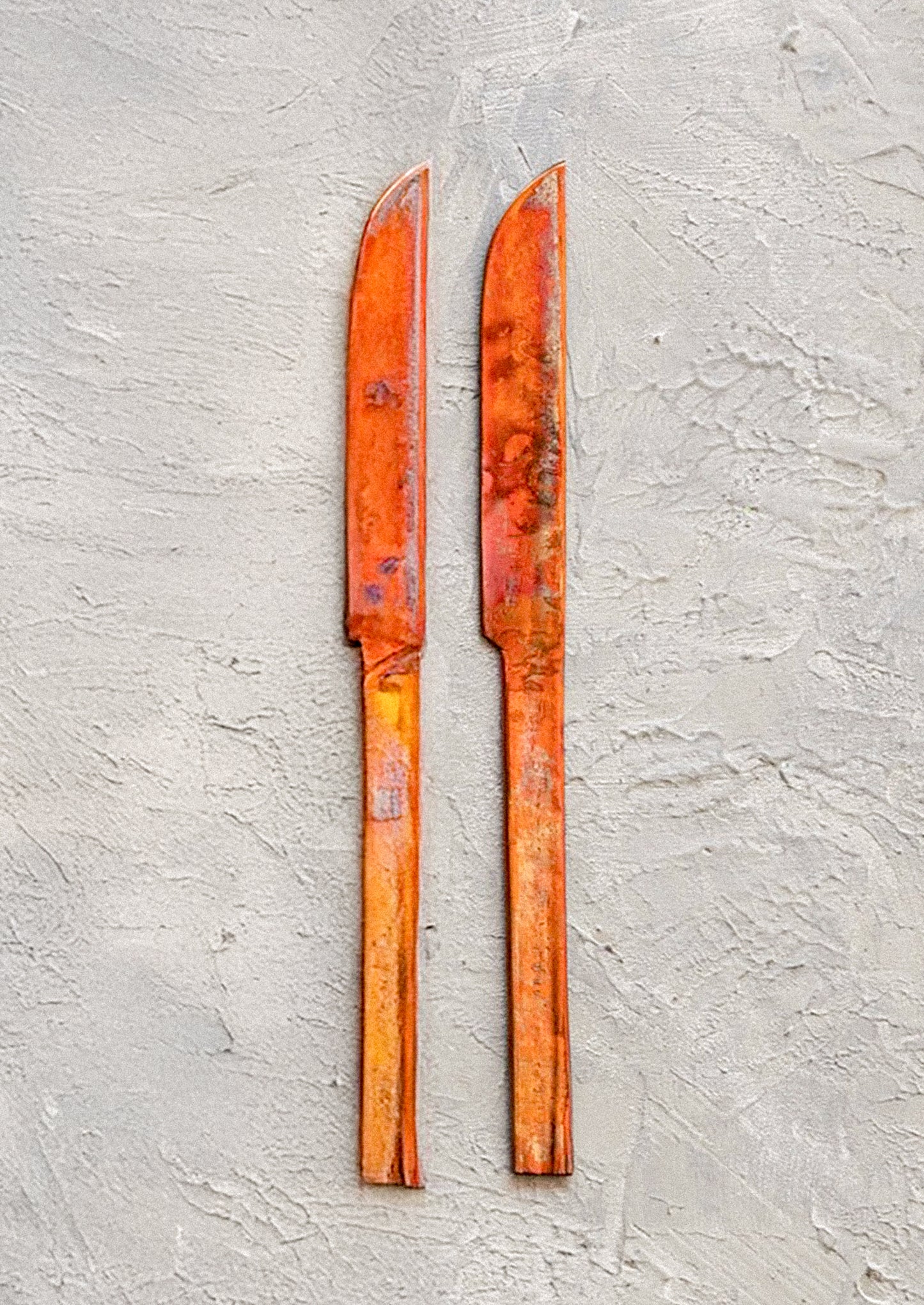 Two copper knives with oxidized finish.