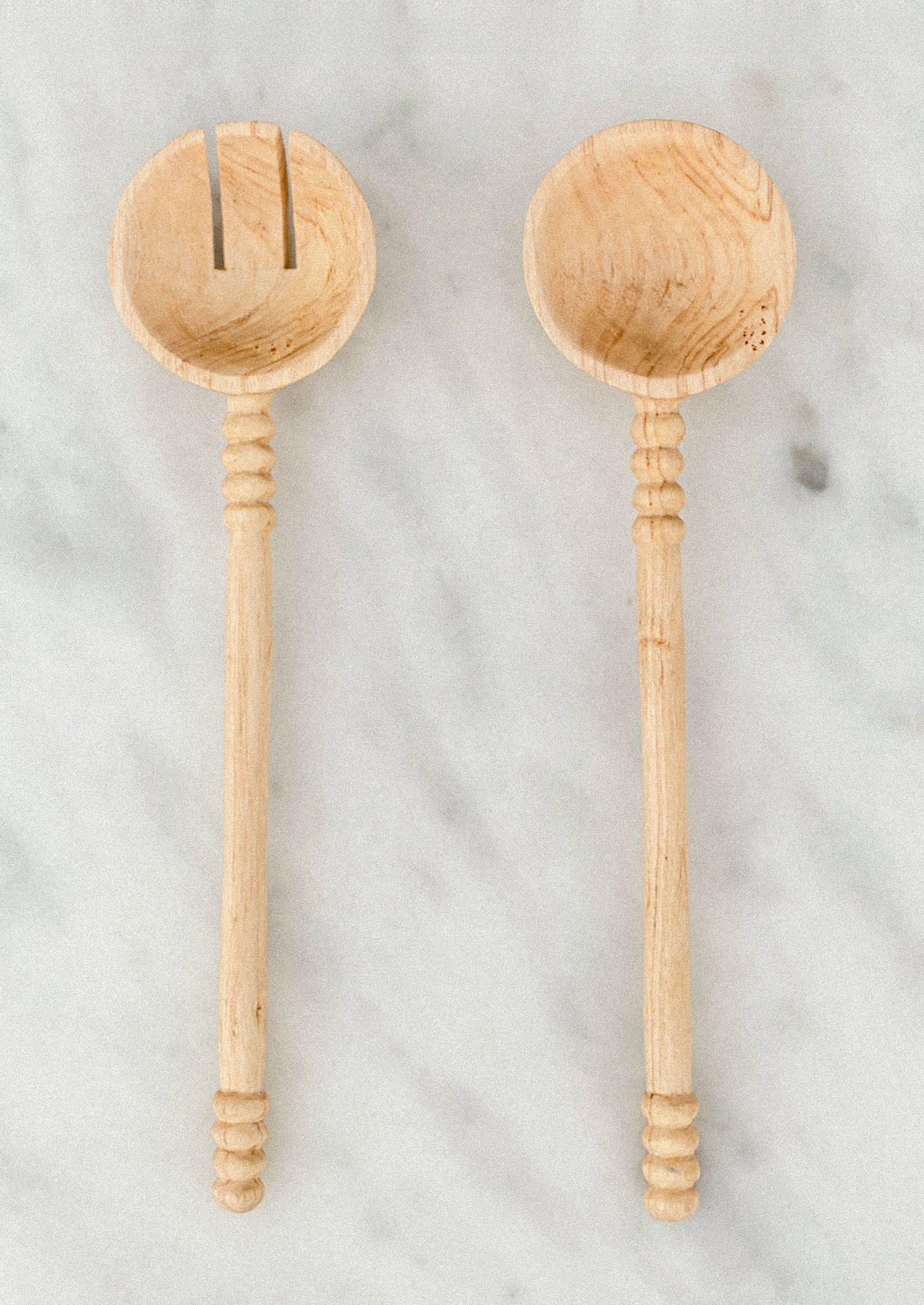 Two wooden spoons on a marble surface