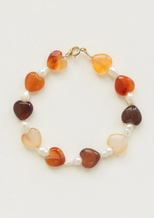 A beaded bracelet with alternating pearl and gemstone heart beads.