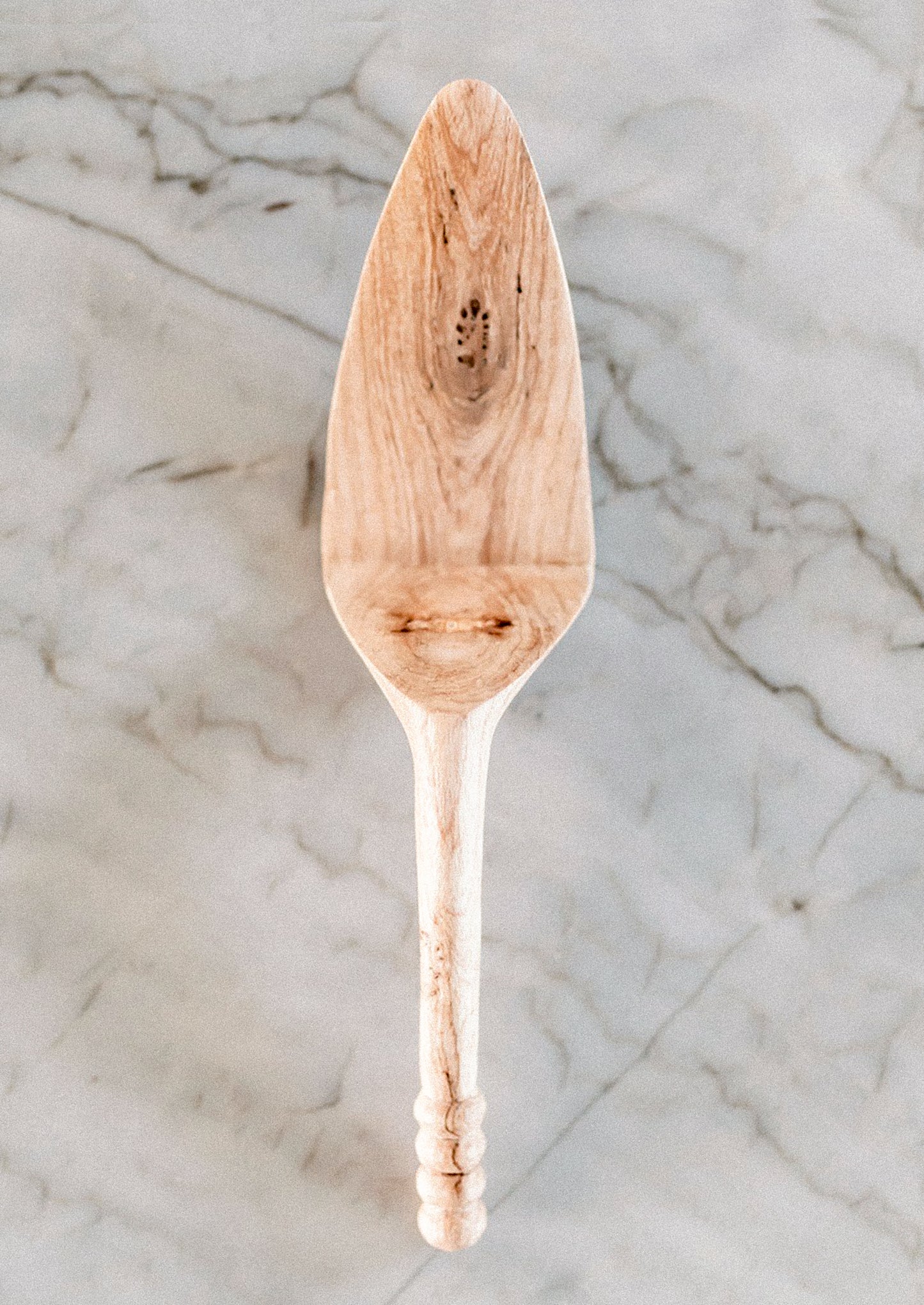 Wooden cake/pie server on a marble surface