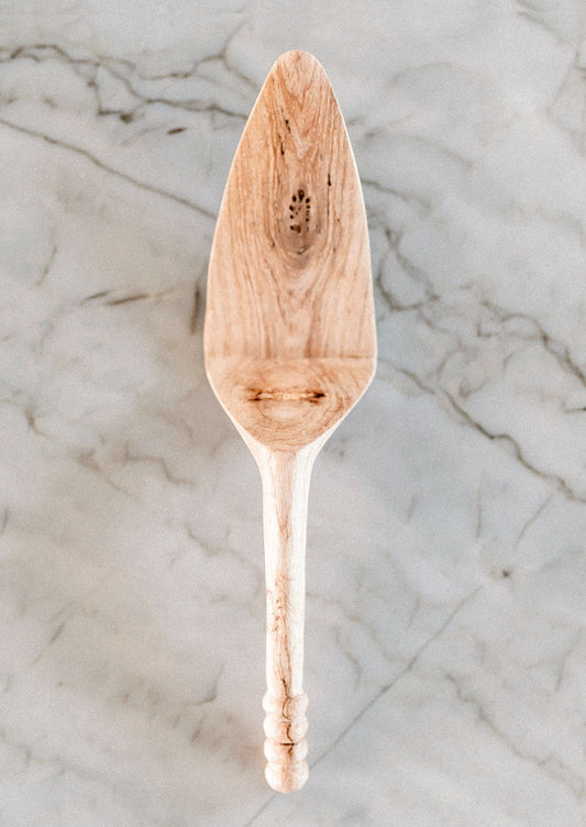 Wooden cake/pie server on a marble surface