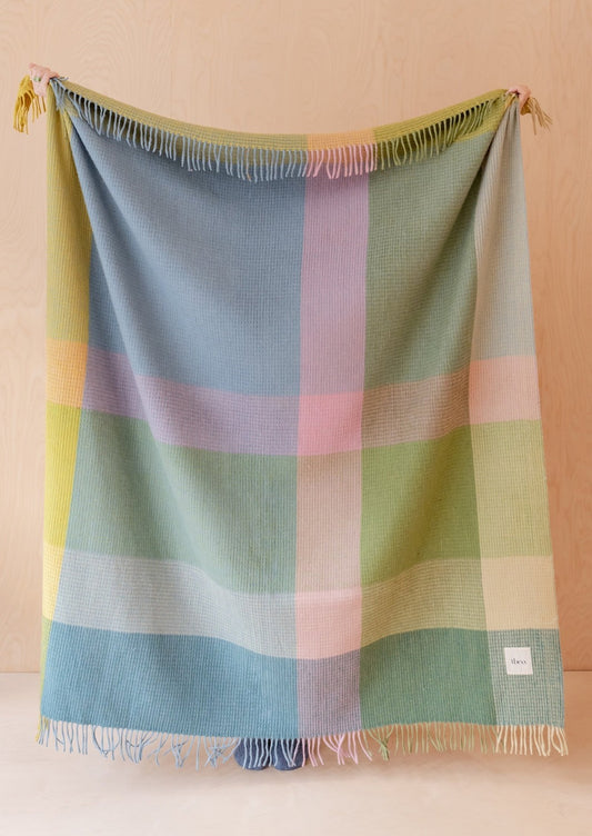 A waffle textured throw blanket in pastel check pattern.