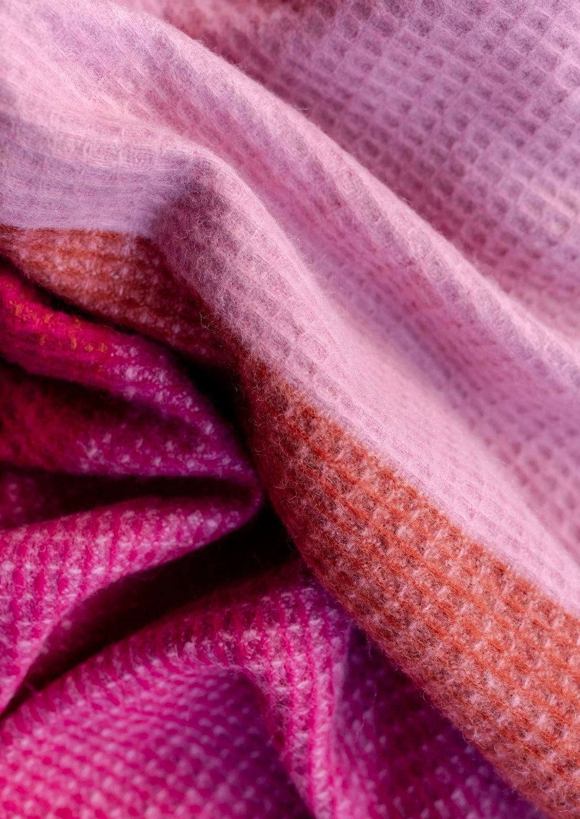 Colorful checkered blanket with waffle texture and fringes.