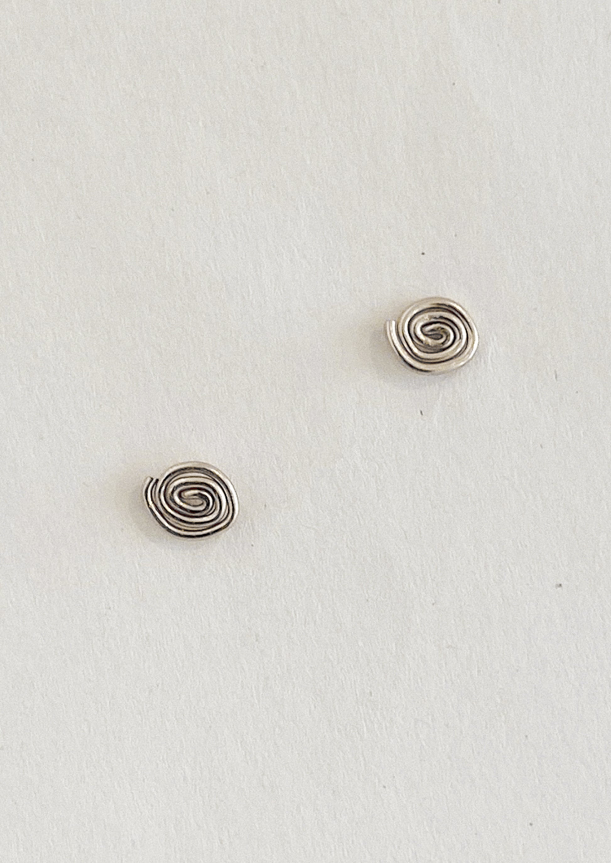 Pair of silver spiral earrings on a light gray background