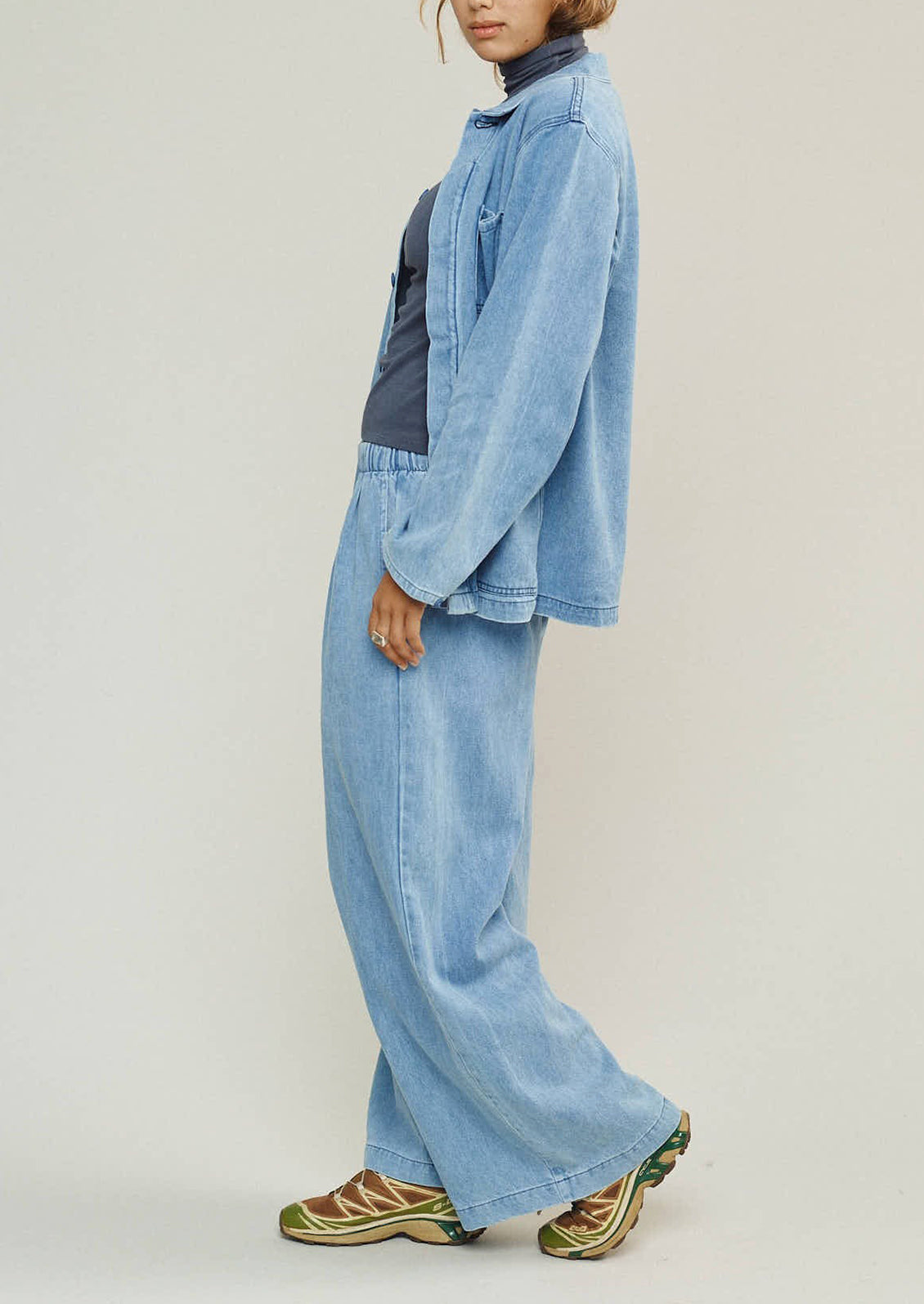 Person wearing a light blue denim outfit on a plain background