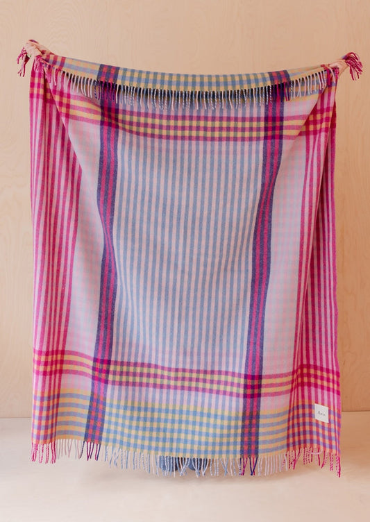 A colorful wool blanket with plaid pattern in pink, purple, yellow and blue hues.