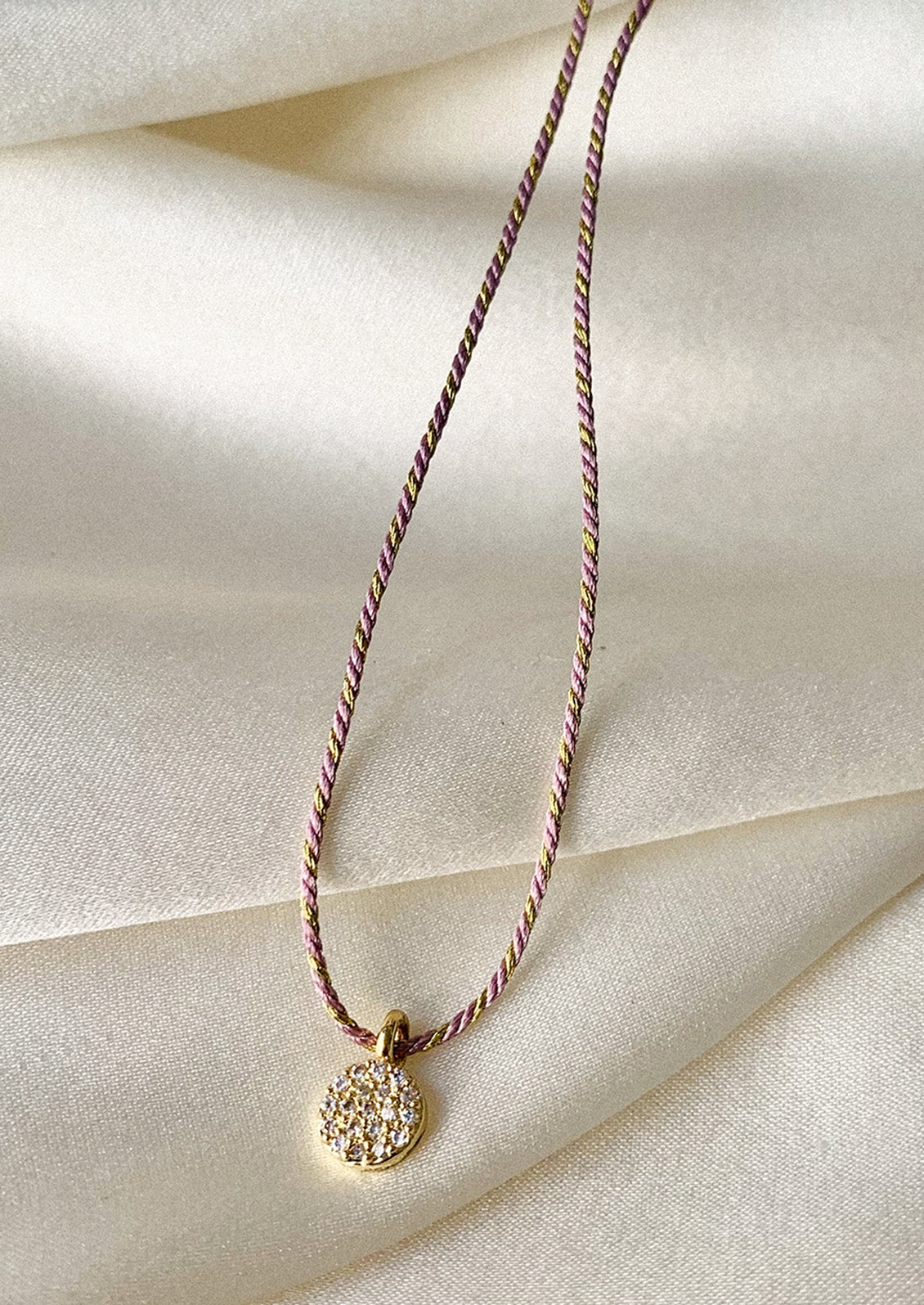 Necklace with a decorative pendant on a light fabric background