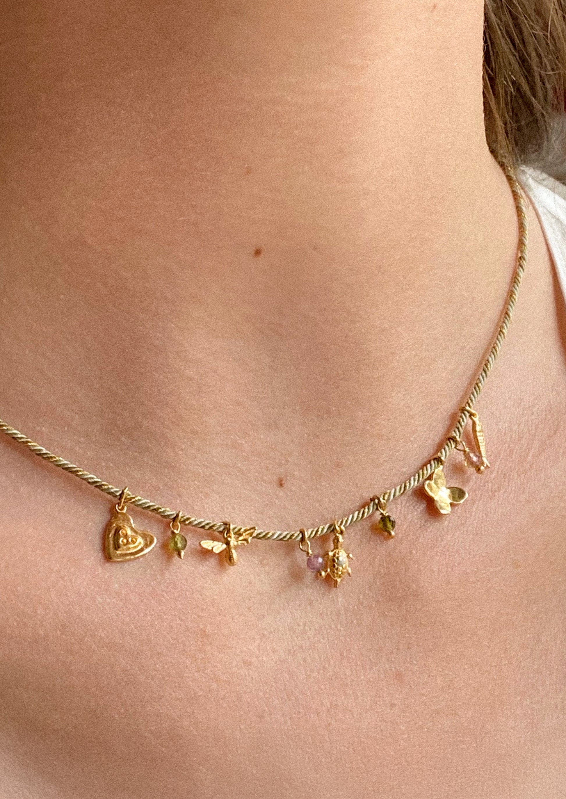Gold necklace with charms on a person's neck