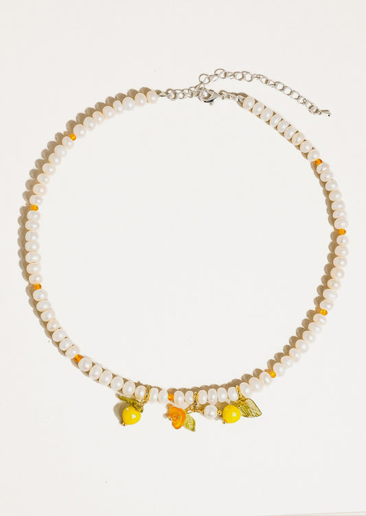 A beaded pearl necklace with lemon charms.