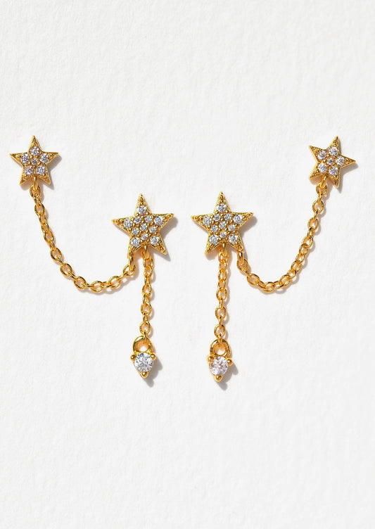 Gold star-shaped earrings with chain details on a white background