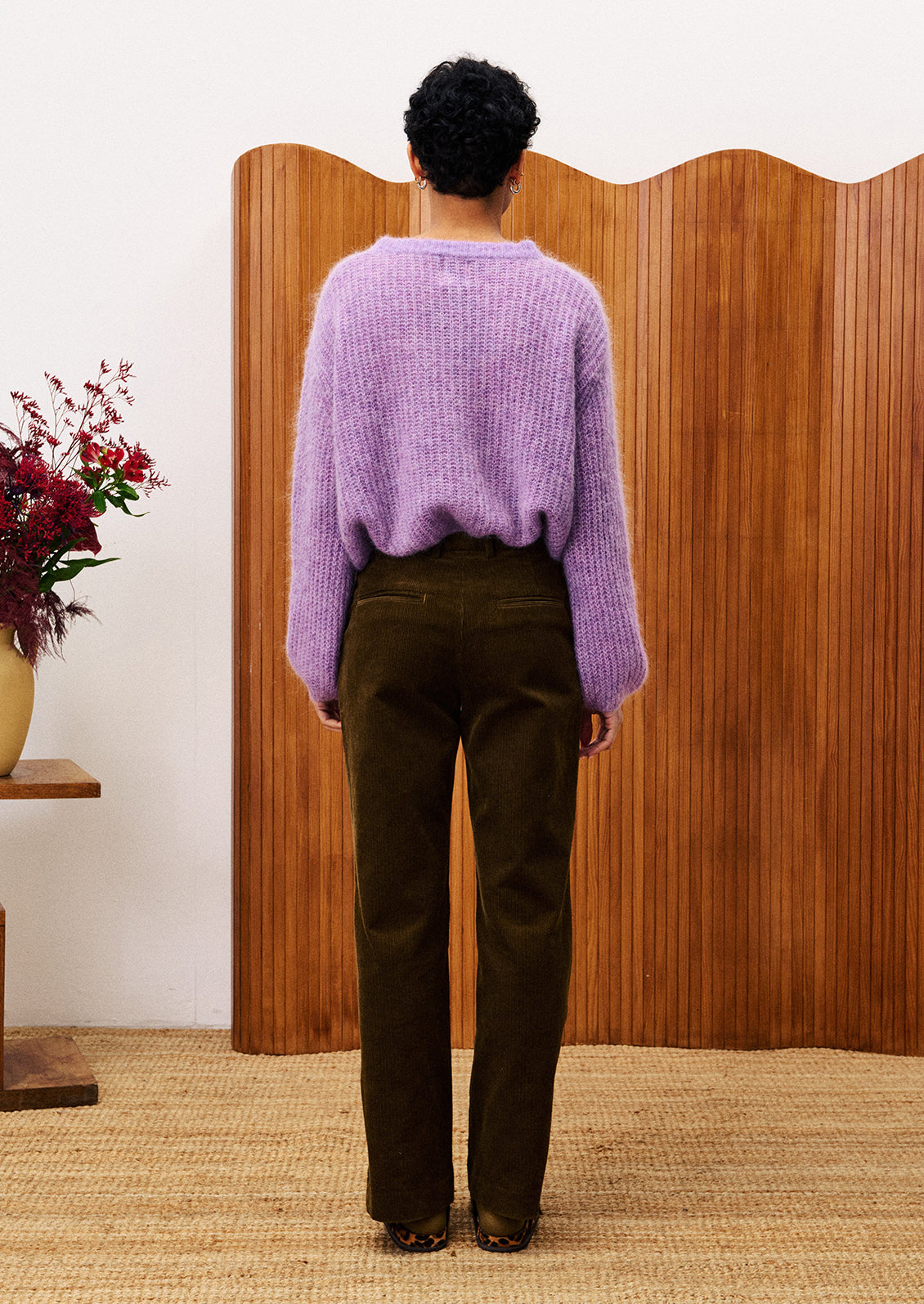 A woman wearing a cardigan sweater in medium purple color.