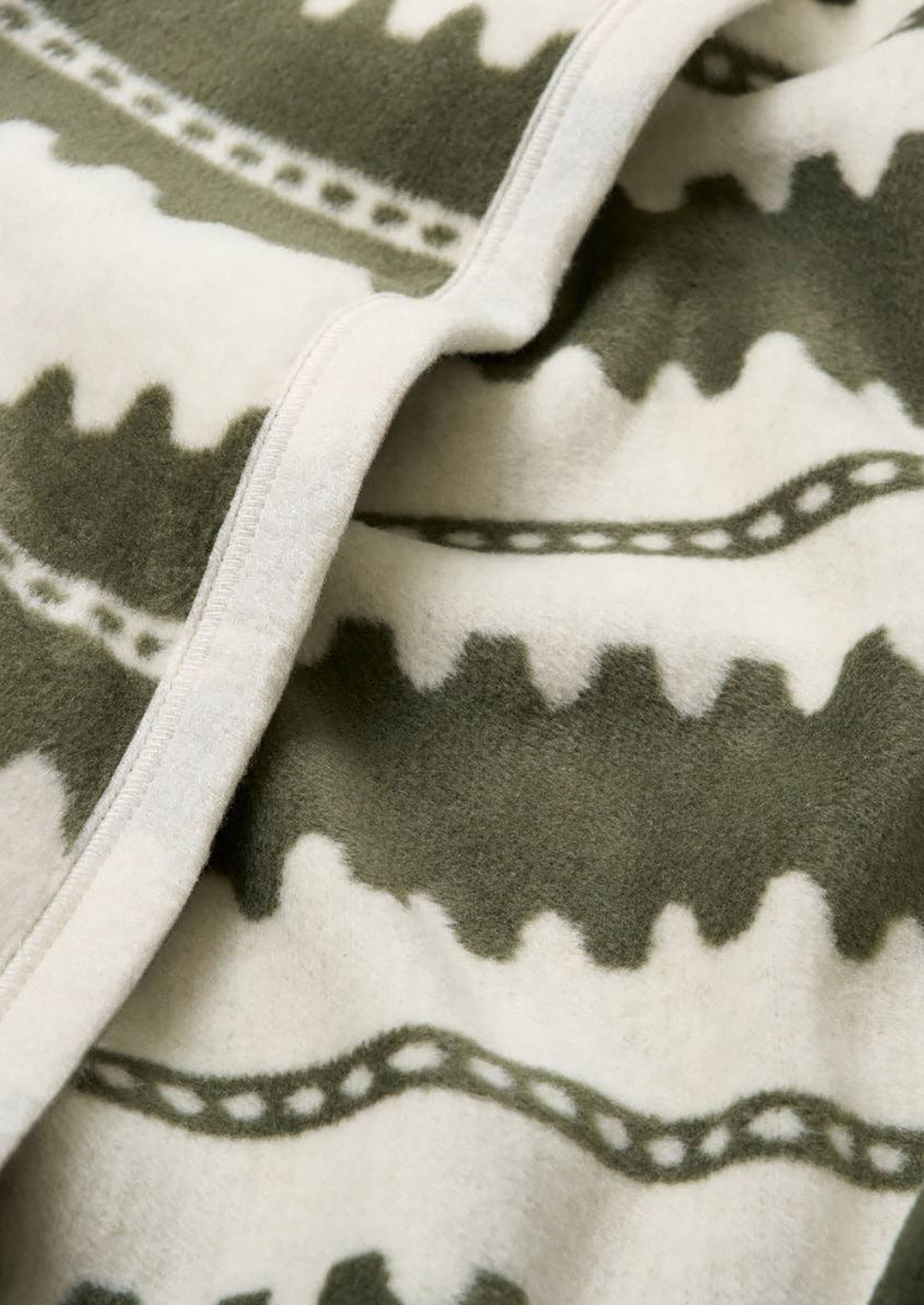 Folded blanket with olive green geometric stripe pattern.