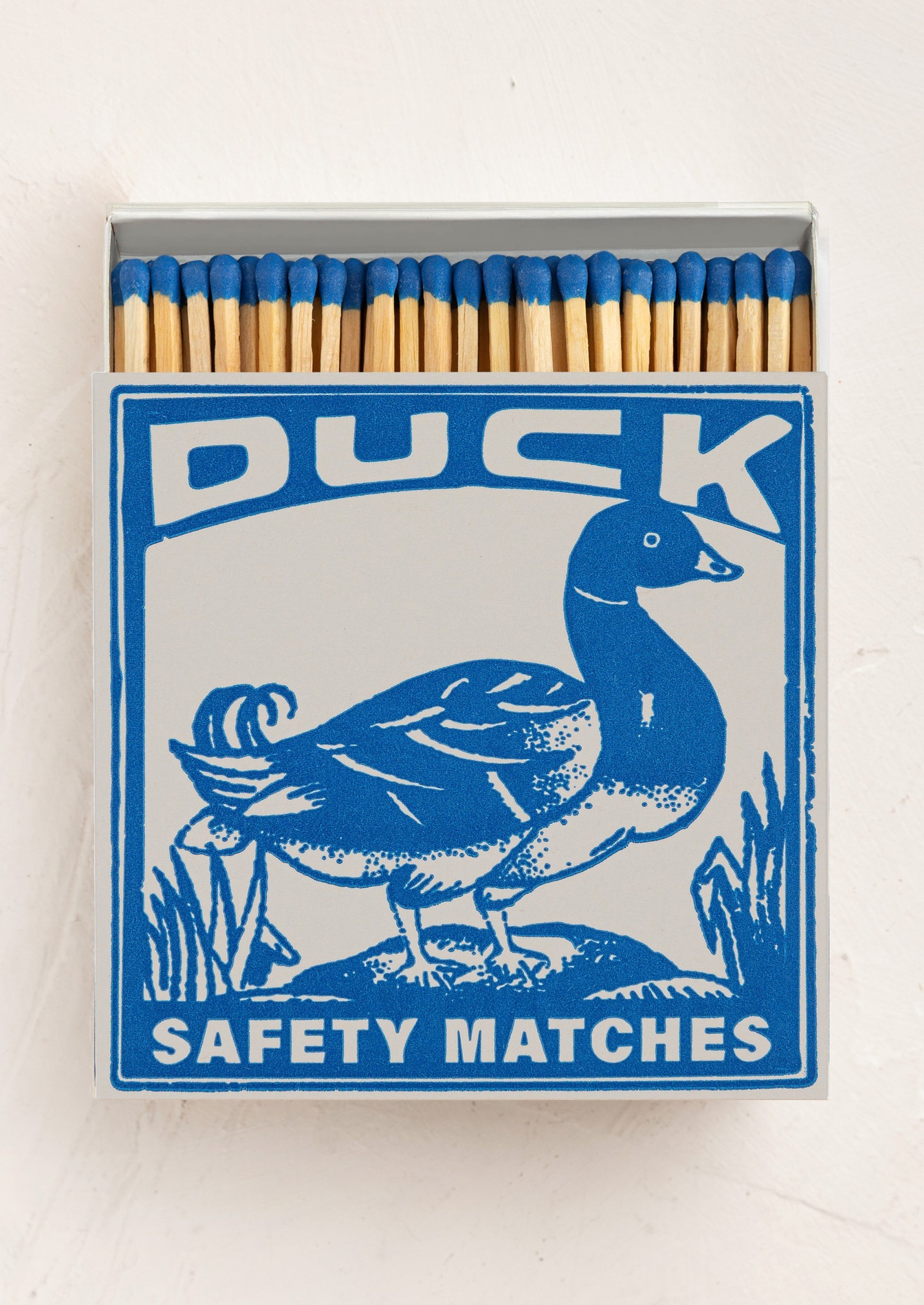 A large square box of matches with duck design on box, matches have blue tips.