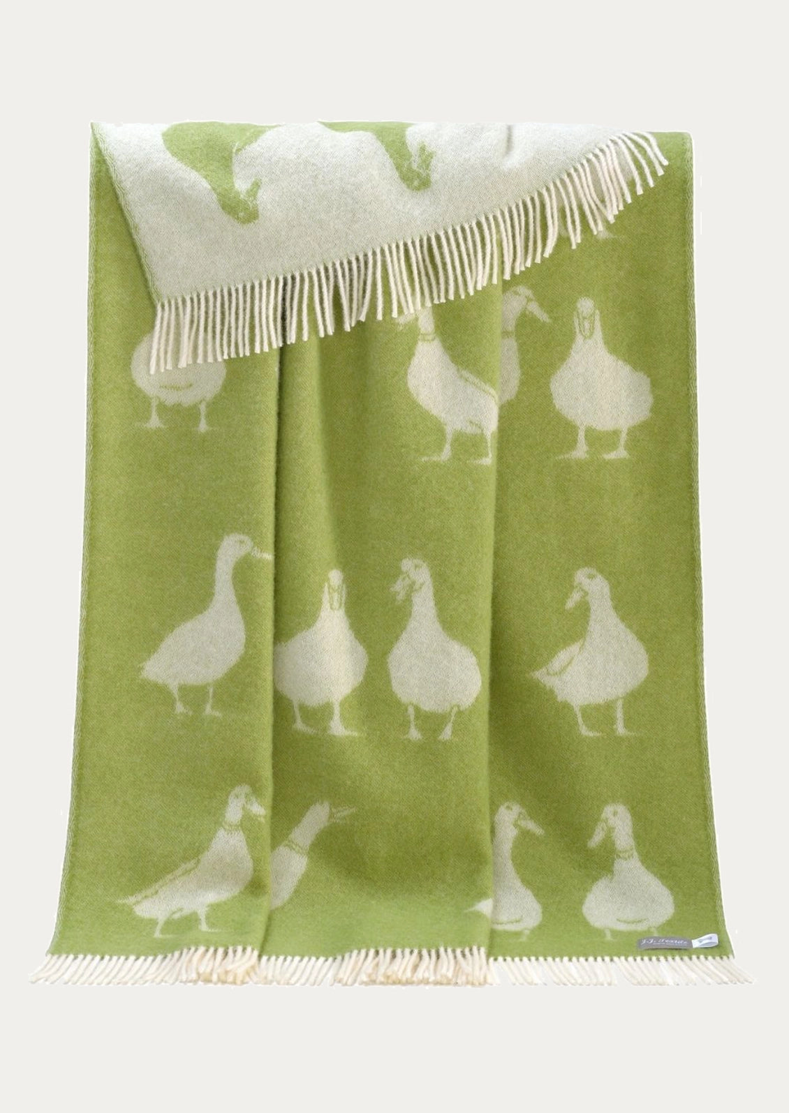 A green woven throw blanket with cream fringed edges and a repeating pattern of white goose silhouettes, displayed against a light off-white background.
