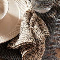 1: A napkin in patterned grey and cream cotton gauze.