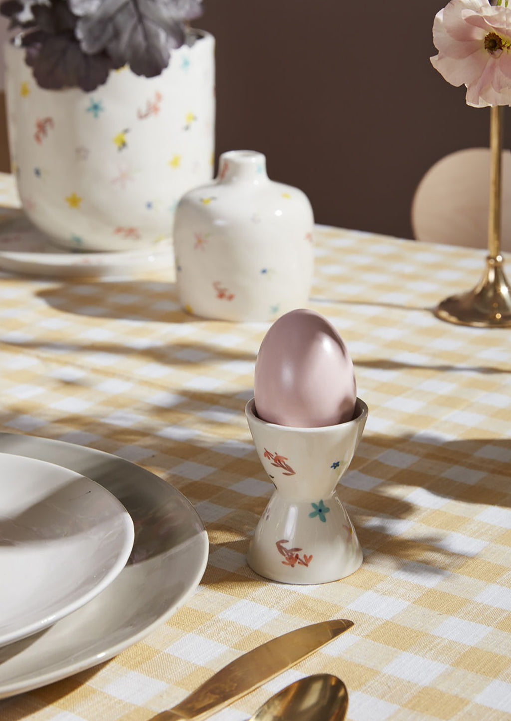 2: A white egg cup with pastel floral pattern.