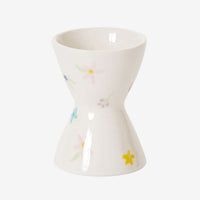 1: A white egg cup with pastel floral pattern.