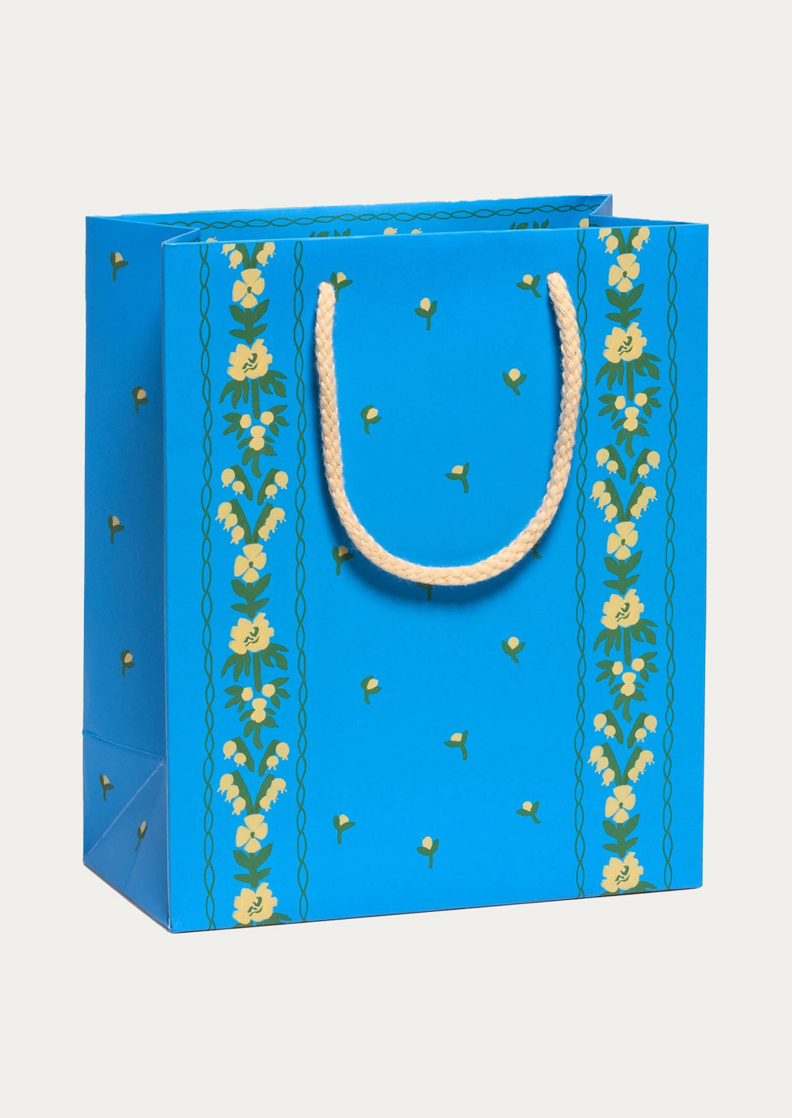 Blue gift bag with floral patterns and a white handle on a light gray background