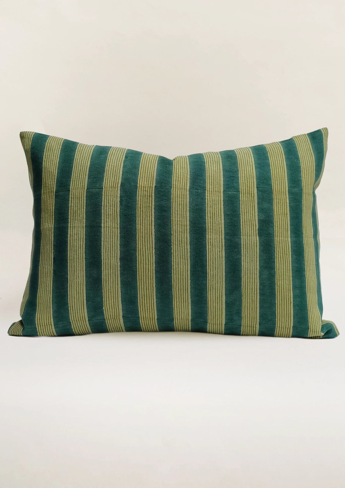 A lumbar pillow in green with stripe pattern.