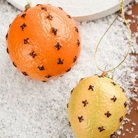 2: Glass ornaments of clove spiked lemon and orange.